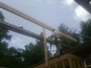 Carpenter setting a ridge beam over a new addition frame — Ice Dam Removal by Roofing Brothers in Vale